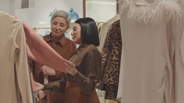 Δύο Πολυεθνικές Κομψές Γυναίκες Κοιτάζοντας Μέσα Από Ρούχα Στο Ράφι — Αρχείο Βίντεο