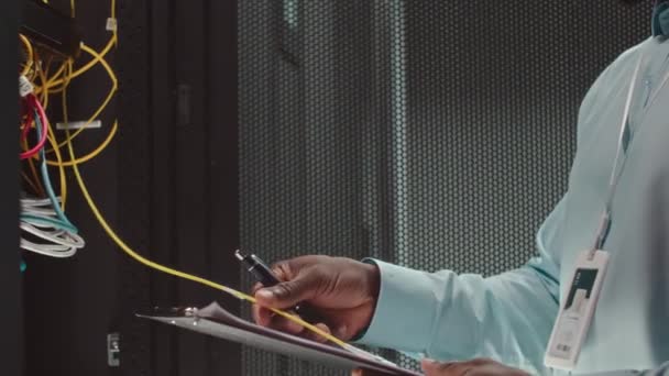 Tanımlanamayan Bilişim Mühendisinin Sunucu Odasındaki Sarı Kabloyu Incelerken Panoya Alırken — Stok video