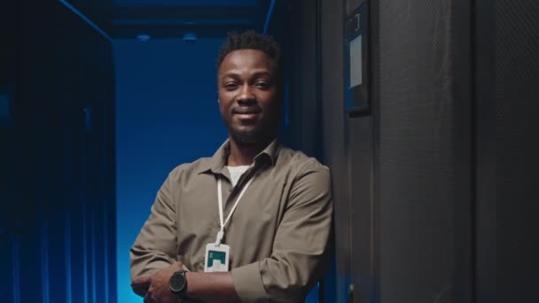 데이터 센터의 서버에 기대는 카메라에 아프리카계 미국인 엔지니어의 초상화 — 비디오
