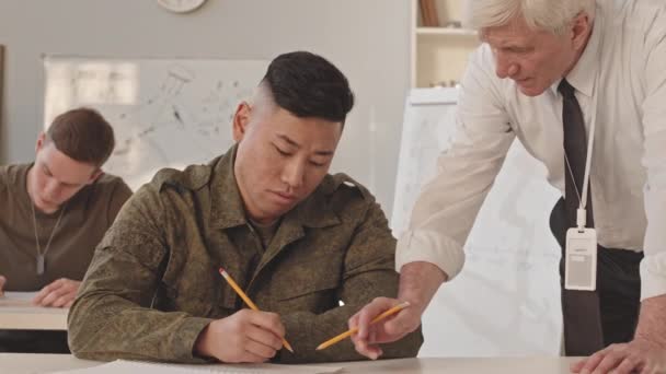 Powoli Starszy Biały Profesor Akademii Wojskowej Rozmawiający Młodym Azjatyckim Żołnierzem — Wideo stockowe