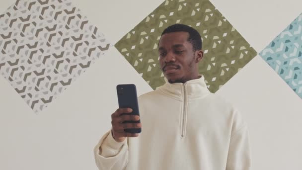 Junger Afroamerikanischer Mann Steht Vor Weißer Wand Der Abstrakte Bilder — Stockvideo