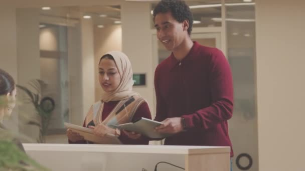 Fiatal Változatos Szabadúszók Érkeznek Modern Coworking Irodába Regisztrálnak Pultnál — Stock videók