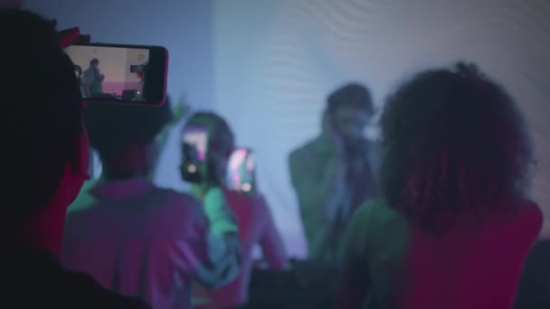在复古派对上 一群拿着智能手机的人在夜总会的舞台上播放了Dj的视频 — 图库视频影像