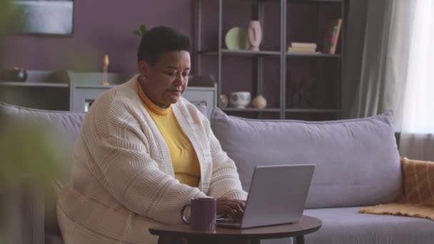 Média Tiro Meados Idade Mulher Negra Sentada Sofá Cinza Aconchegante — Vídeo de Stock