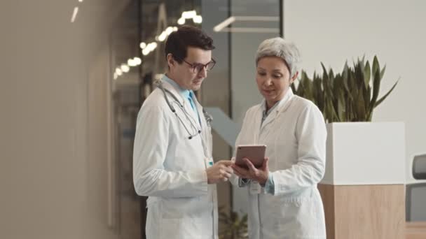 Beyaz Laboratuvar Önlüklü Doktorların Dijital Tablete Bakıp Modern Sağlık Merkezinin — Stok video