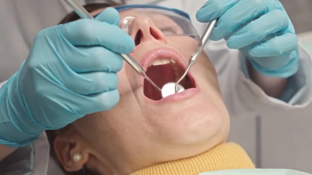 現代のクリニックでプロの歯科検査と治療を受ける女性のクローズアップ — ストック動画