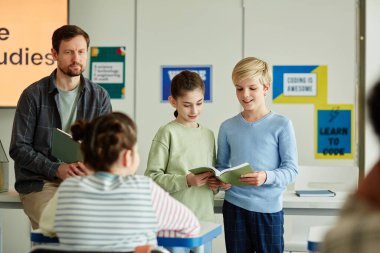 Sınıfın önünde soruları cevaplayan iki çocuğun portresi, boşluğu kopyala
