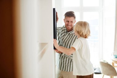 Beyaz duvara asılı mutlu baba ve oğul portresi, kopyalama alanı