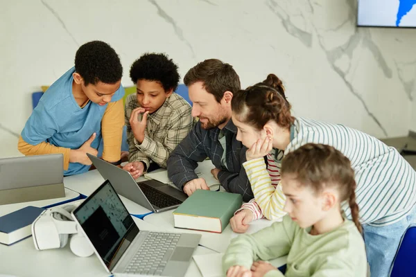 Sınıfta Dizüstü Bilgisayar Kullanan Bir Grup Çocukla Gülümseyen Erkek Öğretmenin — Stok fotoğraf