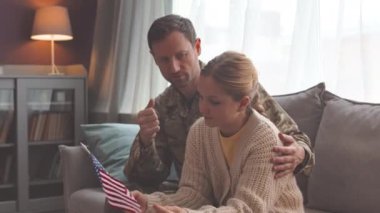 Zoom 'da, askeri üniformalı beyaz bir asker, küçük kızına askerlik hizmetinden bahsederken, oturma odasında kanepede yan yana otururken görülüyor.