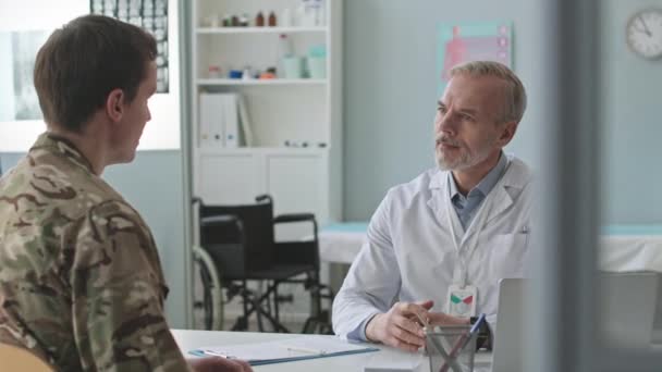 Νεαρός Λευκός Στρατιώτης Επισκέπτεται Γιατρό Στο Νοσοκομείο Συζητώντας Στο Γραφείο — Αρχείο Βίντεο