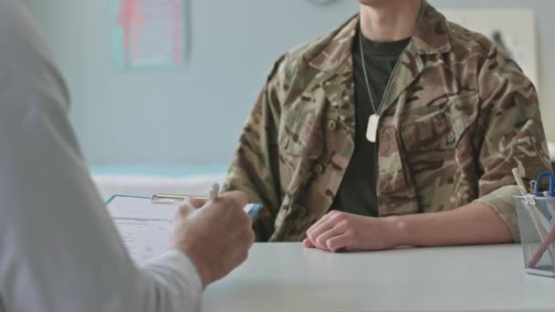 Oříznutý Záběr Nerozpoznatelného Vojenského Lékaře Vyplňující Lékařskou Kartu Vojáka Během — Stock video
