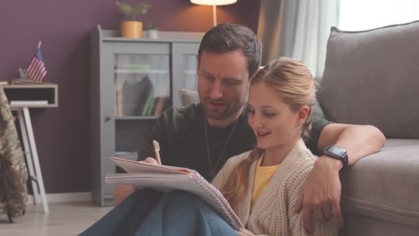 学校の宿題をする自宅で一緒に勉強する19歳の娘を持つ白人父親 — ストック動画