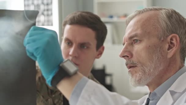 Medium Närbild Militär Läkare Visar Röntgen Bild Till Ung Armé — Stockvideo