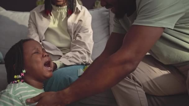 アフリカ系アメリカ人の父親が家にいる間 泣いている小さな娘を世話して慰めます — ストック動画