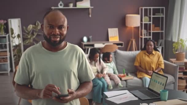 Modern Oturma Odasında Kameraya Gülümseyen Akıllı Telefonlu Genç Siyahi Bir — Stok video