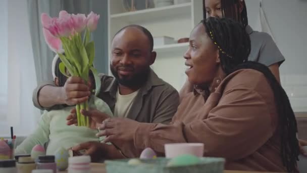 Szczęśliwy Afroamerykanin Daje Piękne Różowe Tulipany Swojej Ukochanej Żonie Wielkanoc — Wideo stockowe