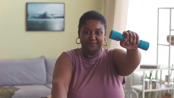 年轻的决心超大的黑人妇女在家里带着哑铃锻炼身体 — 图库视频影像