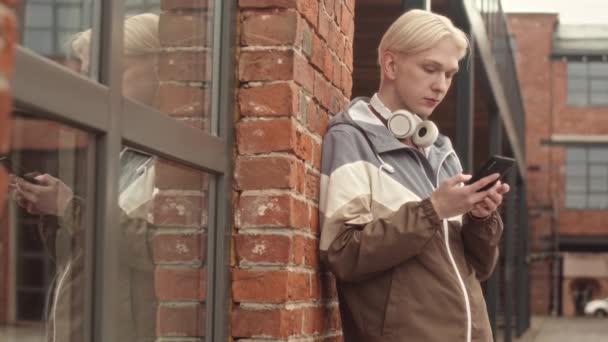Medium Slowmo Portrait Young Blond Caucasian College Boy Wireless Headphones — Stock Video