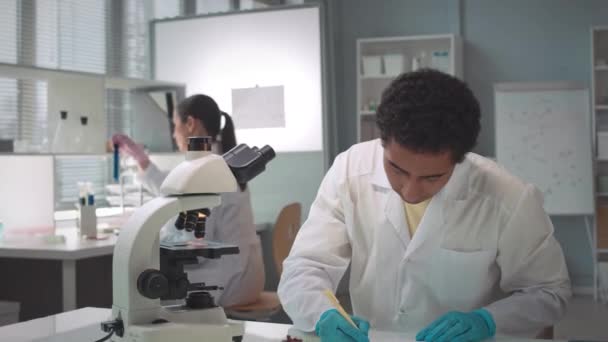 Zoom Del Giovane Scienziato Maschio Biracial Che Guarda Microscopio Mentre — Video Stock