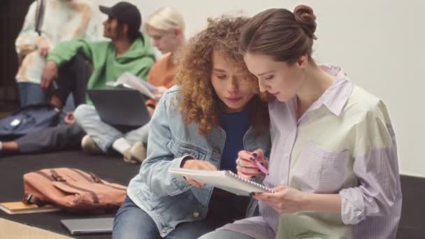 两名年轻貌美的白人女学生在现代大学堂讨论家庭任务的中速 — 图库视频影像