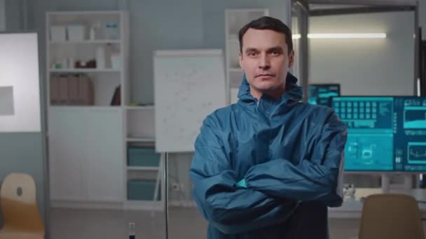 现代研究实验室中身着防护工作服或手持相机 双手交叉站立的严肃白人男性科学家的中像 — 图库视频影像