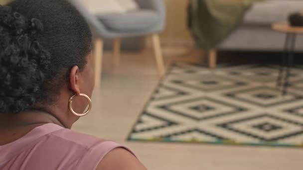 午前中に屋内でヨガ瞑想を実践するアフリカ系アメリカ人女性の肩のショット — ストック動画