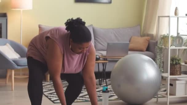 Tilt Shot Young Size Black Woman Rolling Out Mat Floor — Vídeos de Stock