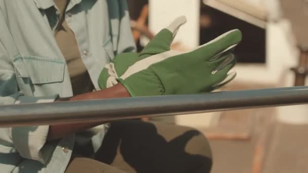 回復中に手袋を着用し 金属製のボートレールにサンドペーパーを使用して認識できない女性のクロップショット — ストック動画