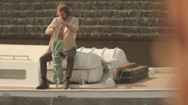 Kafkas denizcisinin güneş ışığıyla aydınlatılmış güvertede yürüdüğü uzun bir çekim.