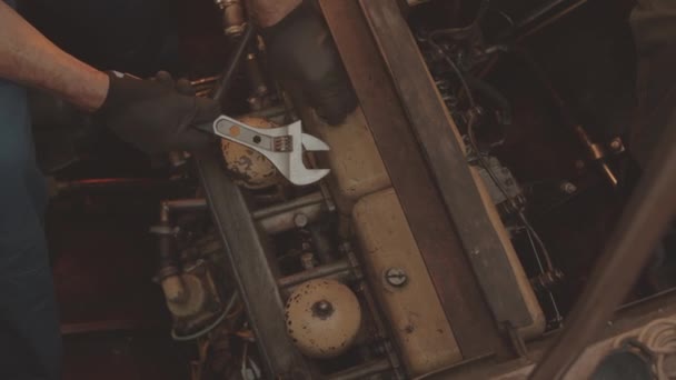 구덩이에서 오래된 엔진을 수리하는 장비로 수없는 기술자의 — 비디오