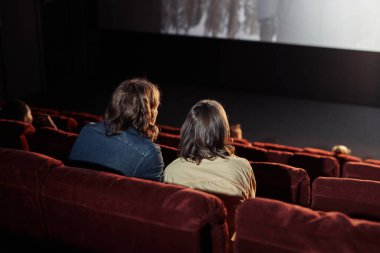 Genç bir çiftin rahat koltuklarda oturup sinemada buluşmaları sırasında birlikte film izlemesi.