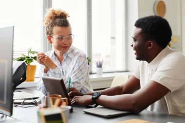 Afrikalı genç bir adam, yeni dijital projeyi, ofisinde otururken meslektaşına anlatıyor.