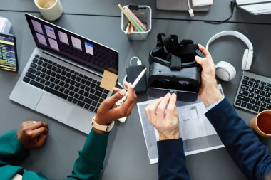 Bilgisayarı ve akıllı telefonu kullanarak yeni sanal gerçeklik gözlüklerini test eden programcıların yüksek açılı görüntüsü