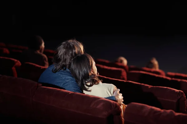 在电影院舒适的座位上看电影时深情情侣拥抱的背景图 — 图库照片