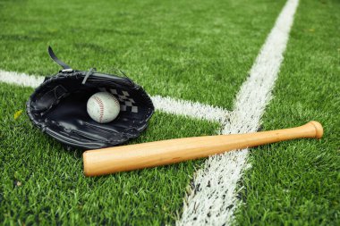 Beyzbol eldiveninin yeşil sahada top ve sopayla yakın çekimi beyzbol maçına hazırlanıyor.