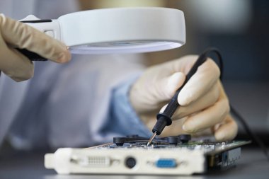 Kadın mühendisin büyüteçle donanımı teftiş ederken makro görüntüsü, boşluğu kopyala
