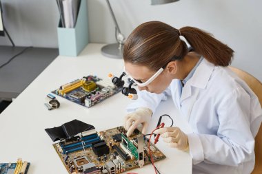 Laboratuvarda elektronik parçalarla çalışan kadın mühendisin yüksek açılı portresi, boşluğu kopyala