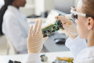 Laboratuvarda elektronik parçaları inceleyen kadın mühendisin kapatılması, kopyalama alanı