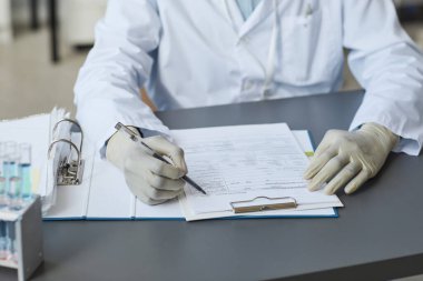 Laboratuvar dosyalarını dolduran kadın tıp bilimcisini kapatın, boşluğu kopyalayın