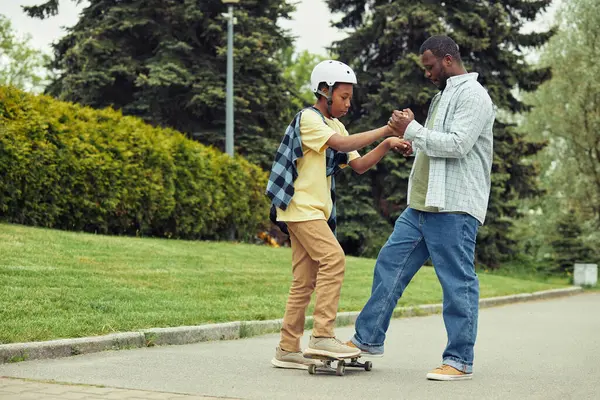 Afrikansk Pappa Hjälper Sin Son Att Stå Skateboard Och Lära — Stockfoto