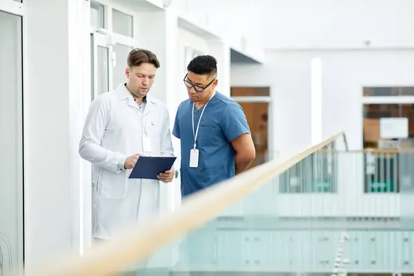 Waist Portrait Two Doctors Looking Clipboard While Standing Balcony Modern — Stock Photo, Image