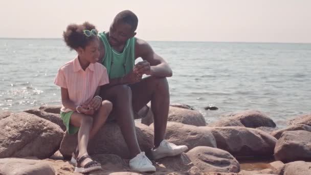 Slowmo Eines Afroamerikanischen Vaters Mit Kleiner Tochter Die Muschel Anschaut — Stockvideo