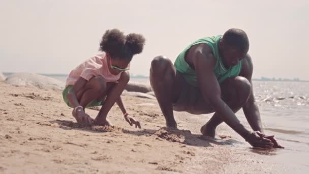 Slowmo Afroameričan Otec Jeho Krásná Dcerka Dřepí Hraje Mokrým Pískem — Stock video