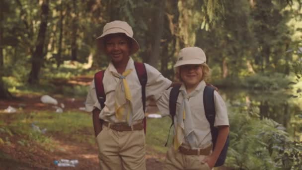 两名年龄很小的白人和非洲裔美国童军儿童在森林中拍照时的中间肖像 — 图库视频影像