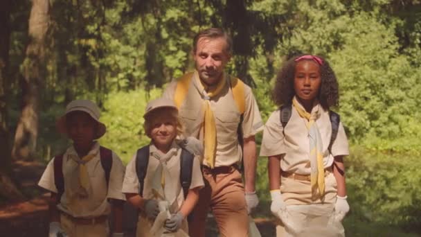 Μέτριο Πορτρέτο Του Scouter Ποικίλα Παιδιά Κρατώντας Σακούλες Σκουπιδιών Ποζάρουν — Αρχείο Βίντεο
