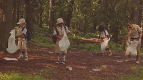 不同的童军和他们的成年领袖在夏天的森林里捡垃圾 — 图库视频影像