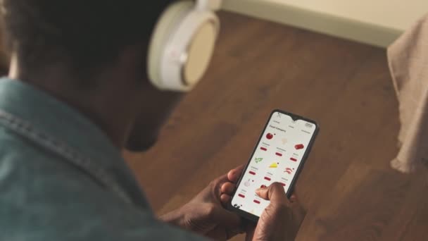 Über Die Schulter Eines Jungen Schwarzen Mit Drahtlosen Kopfhörern App — Stockvideo