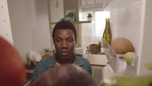 非裔美国年轻人打开冰箱把食品放进冰箱里的Pov镜头 — 图库视频影像