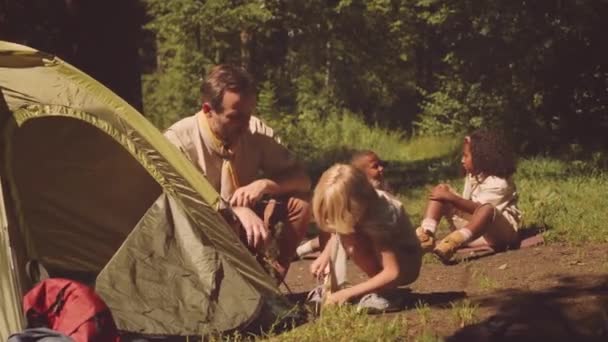 Kleiner Kaukasischer Pfadfinder Und Erwachsener Pfadfinder Bauen Gemeinsam Ihr Zelt — Stockvideo